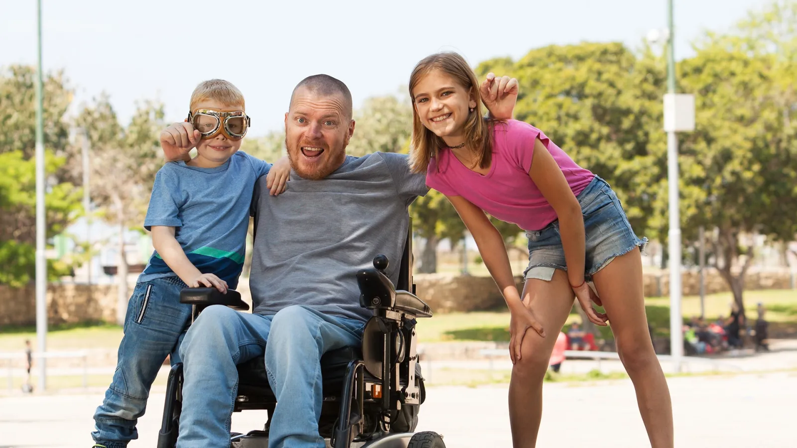 dad in wheelchair outdoors with his kids